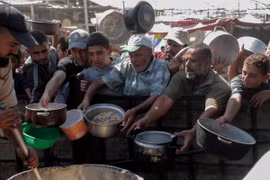 Người dân nhận thức ăn cứu trợ tại thành phố Khan Younis, Dải Gaza. (Ảnh: THX/TTXVN)