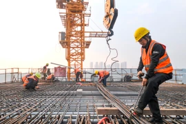 Công nhân làm việc tại công trình xây dựng ở Trùng Khánh (Trung Quốc). (Ảnh: THX/TTXVN)