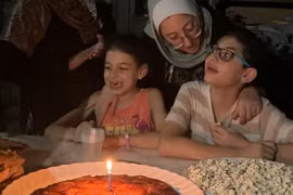 Hashem mừng sinh nhật thứ 12 của mình với chiếc bánh dứa yêu thích, cùng với mẹ Hiba và em gái Basma. (Nguồn: CNN/Ảnh chụp màn hình)