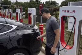 Người dân sạc điện cho ôtô tại một trạm sạc của Tesla ở Arlington, Virginia (Mỹ). (Ảnh: AFP/TTXVN)
