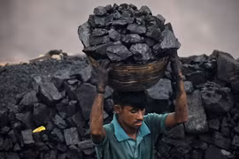 Thu nhặt than đá tại một khu mỏ ở ngoại ô Dhanbad (Ấn Độ), (Ảnh: AFP/TTXVN)
