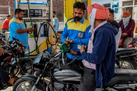 Khách hàng đổ xăng tại một trạm xăng ở Amritsar (Ấn Độ). (Ảnh: AFP/TTXVN)