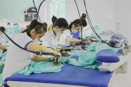 Công nhân may hàng may mặc xuất khẩu. (Ảnh: Nam Thái/TTXVN)