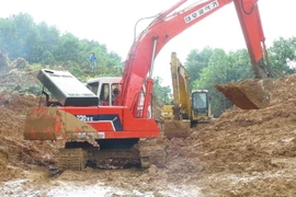 Phương tiện cơ giới nỗ lực xuyên đêm để thông tuyến Quốc lộ 40B. (Ảnh: Đoàn Hữu Trung/TTXVN)