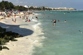Khách du lịch tắm biển tại bang Quintana Roo, Mexico. (Nguồn: AFP/TTXVN)