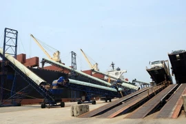 Bốc xếp gỗ dăm tại cảng Dung Quất. (Ảnh: Huy Hùng/TTXVN)