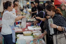 Người dân mua đồ ăn tại một con phố ở Bangkok, Thái Lan. (Nguồn: AFP/TTXVN)