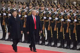 Chủ tịch Trung Quốc Tập Cận Bình (trái) và Tổng thống Mỹ Donald Trump (giữa) duyệt đội danh dự tại lễ đón ở Bắc Kinh ngày 9/11. (Nguồn: AFP/TTXVN)