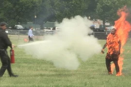 Cảnh sát dùng bình chữa cháy dập lửa trên người nạn nhân. (Nguồn: New York Post)