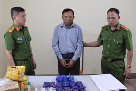 Đối tượng Mùa A Dê cùng tang vật tại cơ quan Công an. (Ảnh: TTXVN)