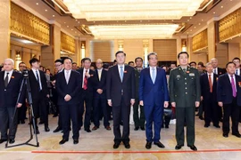 Đại sứ Đặng Minh Khôi cùng các quan chức, đại biểu tham dự Lễ kỷ niệm thực hiện nghi thức chào cờ. (Nguồn: Bùi Tuấn/TTXVN)