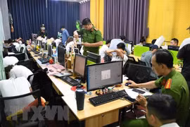 Cơ quan chức năng kiểm tra, khám xét, thu giữ vật chứng tại nơi làm việc của các đối tượng liên quan trong vụ án. (Ảnh: TTXVN phát)