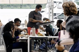 Nhân viên phục vụ tại một nhà hàng ở Alexandria, Virginia (Mỹ). (Ảnh: AFP/TTXVN)