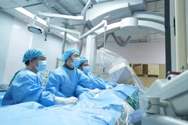 Các bác sỹ Bệnh viện Đại học Y dược thực hiện phẫu thuật thay van động mạch phổi qua da cho người bệnh. (Ảnh: TTXVN phát)