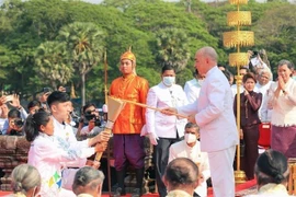 Quốc vương Campuchia Norodom Sihamoni tiến hành Nghi thức châm lửa và khởi động hoạt động rước đuốc cho SEA Games 32 và ASEAN Para Games 12, ngày 21/3/2023. (Ảnh: AKP/TTXVN)