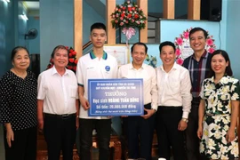 Phó Chủ tịch Ủy ban Nhân dân tỉnh Hà Giang Trần Đức Quý trao thưởng cho em Hoàng Tuấn Dũng. (Ảnh: Minh Tâm/TTXVN)