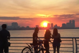Các bạn trẻ ngắm hoàng hôn bên Hồ Tây (Hà Nội), lúc nhiệt độ trong ngày dịu dần. (Ảnh: Ngọc Duy)