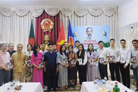 Lãnh đạo Đại sứ quán Việt Nam tại Bangladesh trao tặng bà con Việt Nam các tác phẩm về Bác. (Ảnh: TTXVN phát)