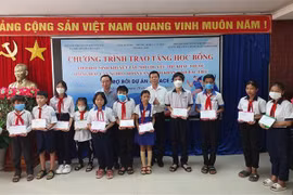 Ông Nguyễn Trọng Đàm - Chủ tịch Hội Bảo tuy Người Khuyết tật và Trẻ em mồ côi Việt Nam và ông Phan Thanh Duy - Phó Chủ tịch Ủy ban Nhân dân tỉnh Bạc Liêu trao học bổng tại chương trình. (Ảnh: Tuấn Kiệt/TTXVN)