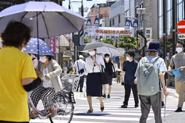 Người dân di chuyển dưới tiết trời nắng nóng tại Tokyo (Nhật Bản). (Ảnh: Kyodo/TTXVN)