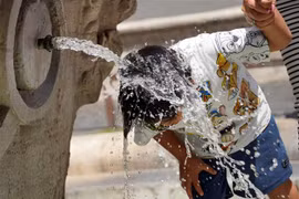 Em nhỏ giải nhiệt tại đài phun nước ở Rome (Italy), ngày 18/7/2023. (Ảnh: THX/TTXVN)