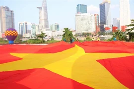 Lá đại kỳ có diện tích 1.800m2 chuẩn bị được kéo lên bầu trời Thành phố Hồ Chí Minh trong Lễ hội Tết Độc lập, sáng 2/9/2022. (Ảnh: Thu Hương/TTXVN)