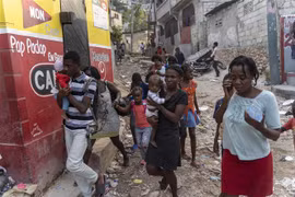 Người dân rời bỏ nhà cửa sau cuộc tấn công của băng nhóm tội phạm tại Port-au-Prince (Haiti). (Ảnh: AFP/TTXVN)