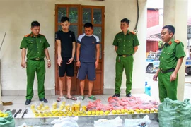 Đối tượng Hải (áo đen) và Hảo cùng số đạn chì tự sản xuất tại Cơ quan Công an. (Ảnh: Hoàng Nguyên/TTXVN)