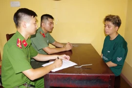 Cán bộ điều tra lấy lời khai đối tượng Nguyễn Hoài Nam. (Nguồn: Công an nhân dân)