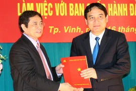 Ông Phạm Minh Chính (bên trái) trao quyết định của Bộ Chính trị phân công ông Nguyễn Đắc Vinh giữ chức Bí thư Tỉnh ủy Nghệ An. (Ảnh: Tá Chuyên/TTXVN)