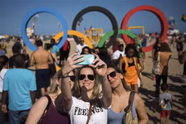 Khách du lịch chụp ảnh tại một bãi biển ở Rio de Janeiro trong dịp Olympic. (Nguồn: Xinhua)