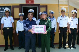 Đoàn công tác trao quà cho cán bộ trạm hải đăng đảo Đá Lát. (Ảnh: Tiến Đạt/Vietnam+) 