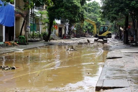 Huy động máy xúc, san gạt, dọn dẹp bùn đất trên đường Thanh Niên, phường Hồng Hà, thành phố Yên Bái. (Ảnh: Thế Duyệt/TTXVN)