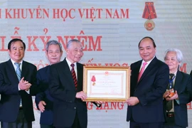 Thủ tướng Nguyễn Xuân Phúc trao tặng Huân chương Lao động Hạng Nhất lần thứ II cho Hội Khuyến học Việt Nam. (Ảnh: Thống Nhất/TTXVN)