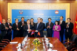 Chủ tịch Mặt trận Tổ quốc Việt Nam Nguyễn Thiện Nhân và Chủ tịch Mặt trận Lào Xây dựng đất nước Saysomphone Phomvihane trao đổi văn kiện ký kết hợp tác làm việc. (Ảnh: Nguyễn Dân/TTXVN)