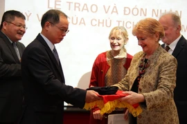 Đại sứ Việt Nam tại Pháp Nguyễn Ngọc Sơn đón nhận chiếc mũ dạ từ bà Claire Biquard (con gái ông Pierre Biquard). (Ảnh : Bích Hà/TTXVN) 
