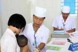 Tiêm chủng cho trẻ em tại điểm tiêm chủng xã Quảng Bình, huyện Quảng Xương (Thanh Hóa), sáng 14/5. (Ảnh: Dương Ngọc/TTXVN) 