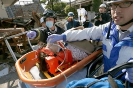 Một phụ nữ được lực lượng cứu hộ đưa ra khỏi đống đổ nát sau trận động đất ở Mashiki, tỉnh Kumamoto ngày 16/4. (Nguồn: AFP/TTXVN) 