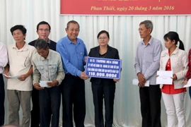 Ông Trương Hòa Bình, Chánh án Tòa án Nhân dân tối cao tặng tiền hỗ trợ cho đồng bào vùng hạn hán. (Ảnh: Nguyễn Thanh/TTXVN)