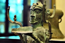 Cây đèn đồng hình người quỳ (văn hóa Đông Sơn) - một trong những bảo vật quốc gia. (Ảnh: Phạm Kiên/TTXVN)