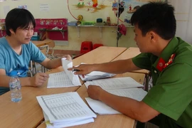 Cảnh sát điều tra lấy lời khai với các đối tượng bị bắt giữ. (Ảnh: Đức Thọ/TTXVN)