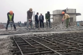 Các lực lượng thi công tiến hành phá dỡ phần vi phạm tại tầng 19 tòa tòa nhà 8B Lê Trực. (Ảnh: Nguyễn Văn Cảnh/TTXVN)