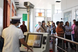 Kiểm tra thân nhiệt khách nhập cảnh ở cửa khẩu. (Ảnh: Phương Vy/TTXVN)