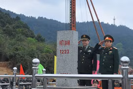 Hai Bộ trưởng Quốc phòng tiến hành nghi lễ chào Cột mốc 1223 tại Cửa khẩu Chi Ma. (Ảnh: Trọng Đức/TTXVN)
