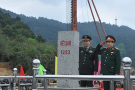 Hai Bộ trưởng Quốc phòng tiến hành nghi lễ chào Cột mốc 1223 tại Cửa khẩu Chi Ma. (Ảnh: Trọng Đức/TTXVN)