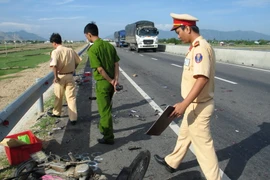 Cảnh sát khám nghiệm hiện trường vụ tai nạn. (Ảnh: Công Thử/TTXVN)