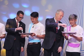 Các đại biểu tham gia thực hiện thao tác test nước bọt với bộ tự xét nghiệm HIV tại lễ khởi động. (Ảnh: Phương Vy/TTXVN)