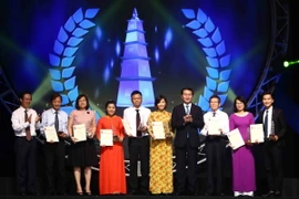 Chủ tịch nước Trần Đại Quang và ông Võ Văn Thưởng, Ủy viên Bộ Chính trị, Trưởng Ban Tuyên giáo Trung ương trao giải A cho các tác giả đoạt giải. (Ảnh: Minh Quyết/TTXVN)
