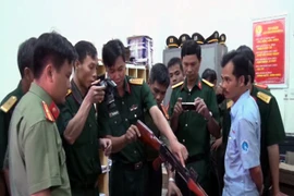Lực lượng chức năng kiểm tra, phân loại các loại vũ khí để lập biên bản tạm giữ. (Ảnh: Đoàn Hữu Trung/TTXVN)