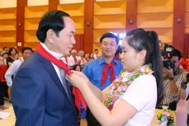 Thiếu niên Thủ đô Hà Nội đeo khăn quàng đỏ cho Chủ tịch nước Trần Đại Quang. (Ảnh: Nhan Sáng/TTXVN) 